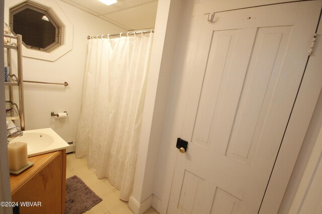 bathroom featuring a shower with curtain, vanity, and baseboard heating