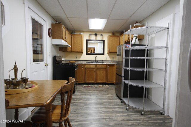 kitchen featuring a paneled ceiling, dark hardwood / wood-style flooring, sink, and black range with electric cooktop