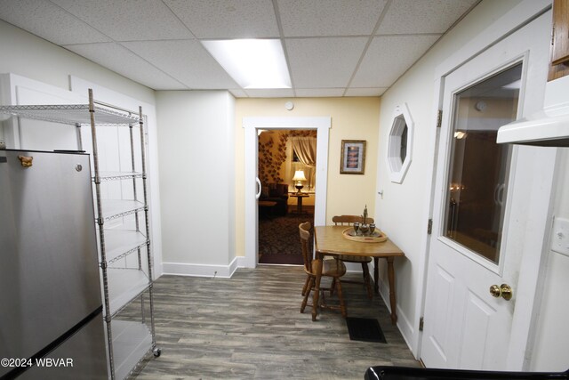 interior space with a drop ceiling and hardwood / wood-style flooring