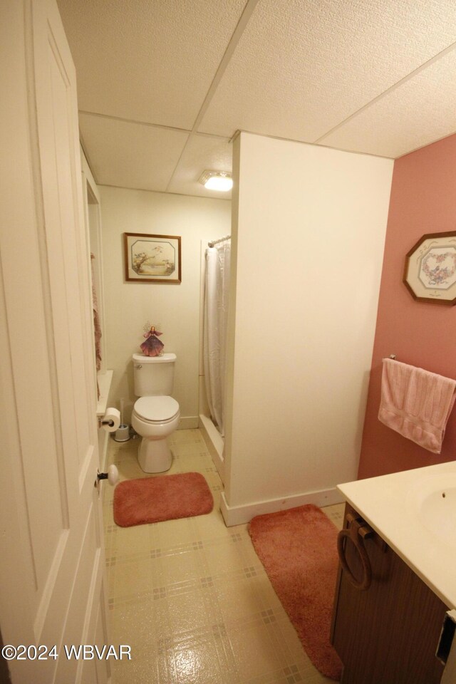 bathroom with a paneled ceiling, vanity, a shower with shower curtain, and toilet