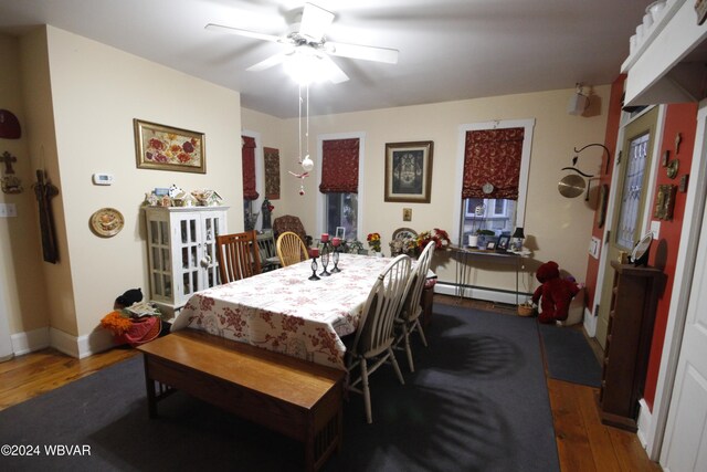 dining room with dark hardwood / wood-style flooring, a baseboard radiator, and ceiling fan