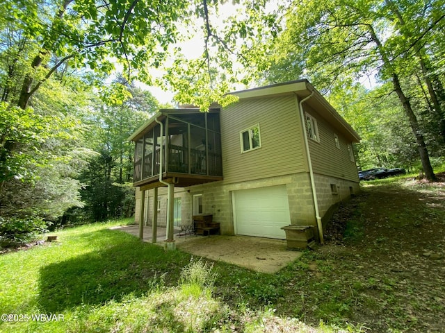 10296 Renovo Rd, North Bend, PA 17760 - rear view of house with a sunroom, an attached garage, and a patio