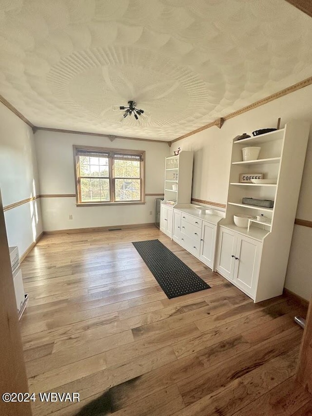 interior space featuring light wood-type flooring and ornamental molding