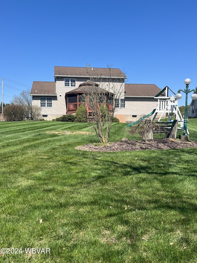 rear view of house with a gazebo and a yard