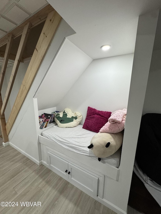 bedroom with light hardwood / wood-style flooring and lofted ceiling