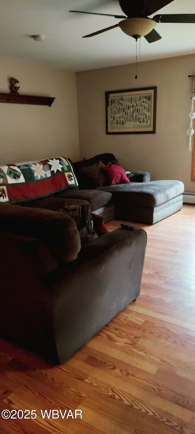 living room featuring a baseboard radiator, ceiling fan, and wood finished floors