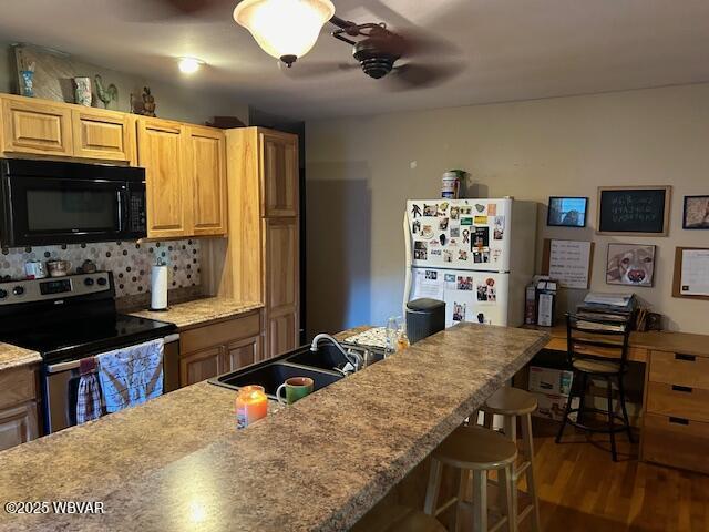 5477 Bloomingrove Rd, Cogan Station, PA 17728 - kitchen with freestanding refrigerator, a sink, stainless steel electric stove, black microwave, and wood finished floors