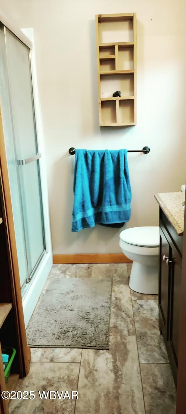 bathroom with toilet, a shower stall, and vanity