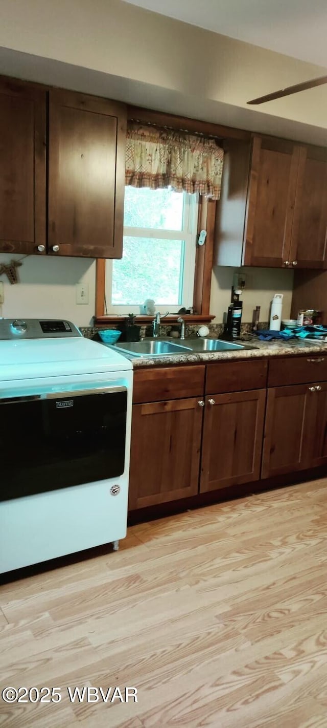 kitchen with a sink and light wood-style flooring