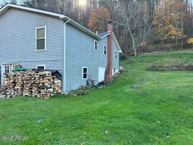 5477 Bloomingrove Rd, Cogan Station, PA 17728 - view of side of home with a chimney and a lawn