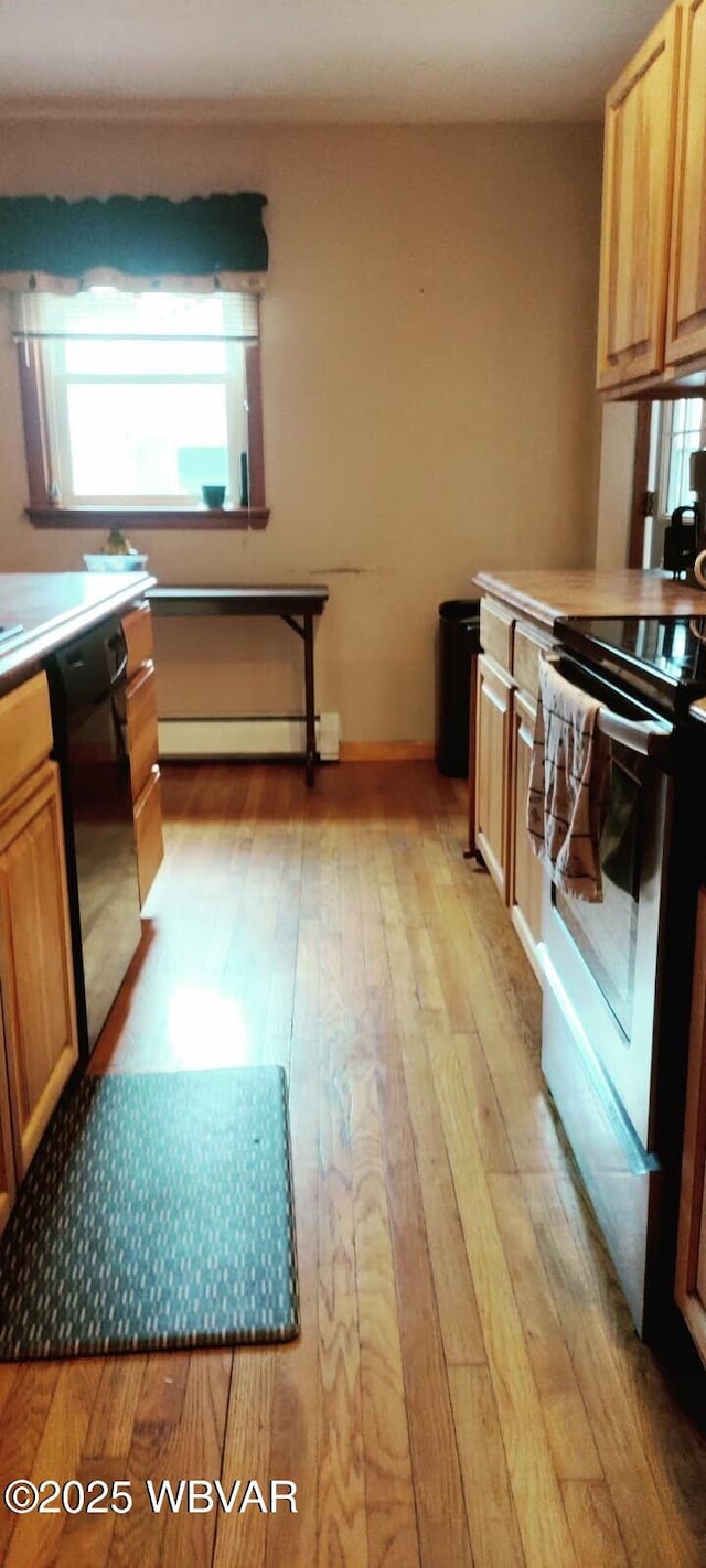 kitchen with light wood finished floors, light countertops, a baseboard heating unit, stainless steel range with electric stovetop, and dishwasher