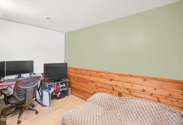 bedroom featuring wood walls and light wood-type flooring