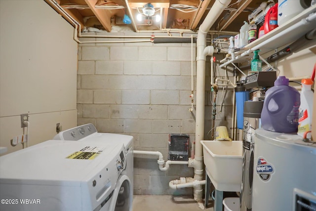 clothes washing area featuring electric water heater, sink, and washer and dryer