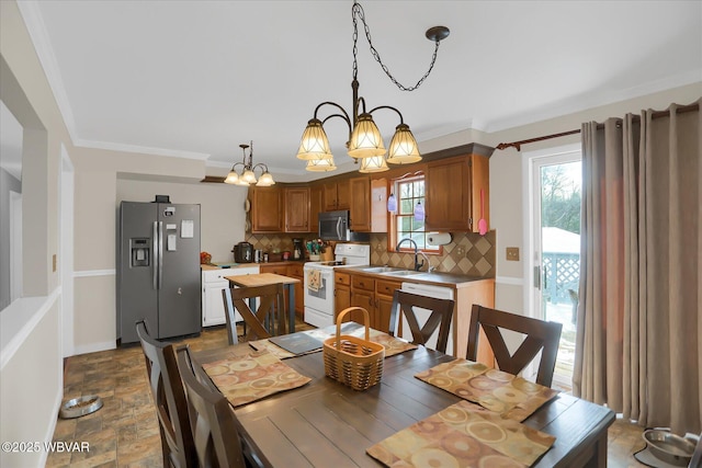 dining room with sink, a chandelier, and crown molding