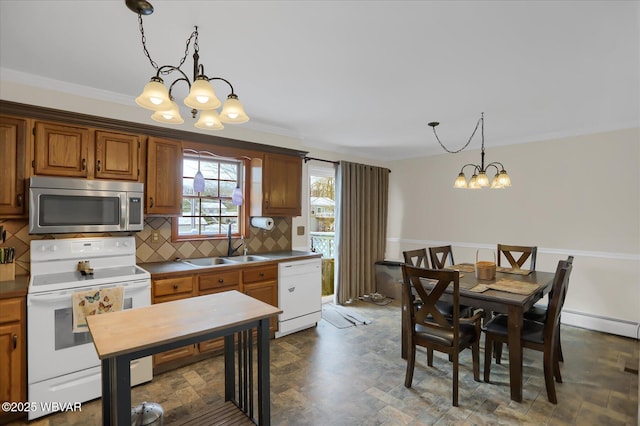 kitchen featuring crown molding, decorative light fixtures, sink, white appliances, and decorative backsplash