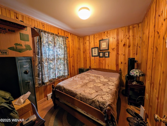 bedroom with wooden walls and hardwood / wood-style floors