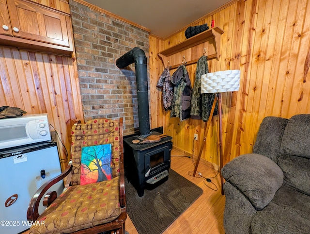 interior space with hardwood / wood-style floors, wooden walls, and a wood stove