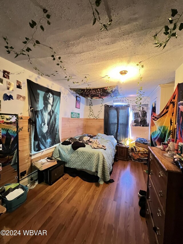 bedroom with a textured ceiling and dark hardwood / wood-style flooring