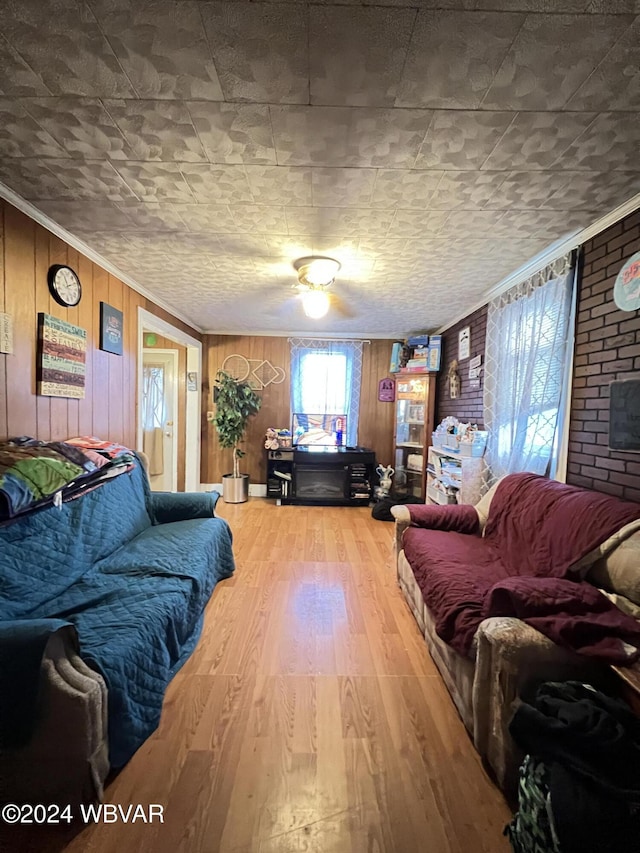 living room featuring wooden walls, wood-type flooring, brick wall, and ornamental molding