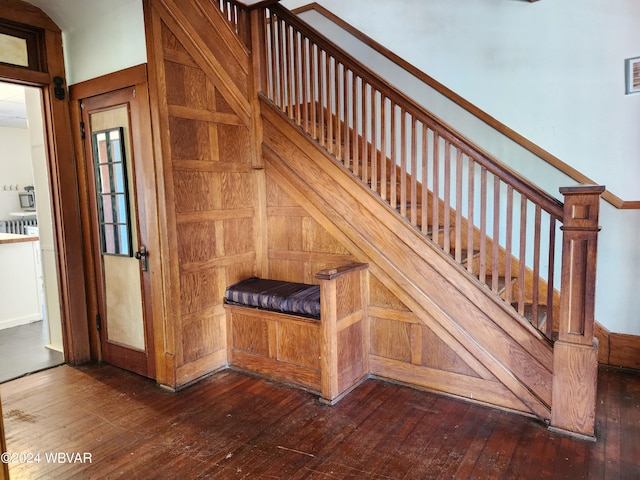 staircase featuring hardwood / wood-style flooring and wood walls