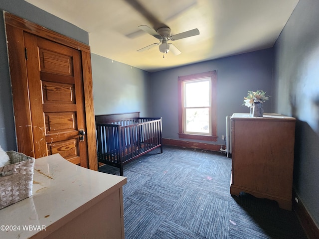 bedroom with ceiling fan and a nursery area