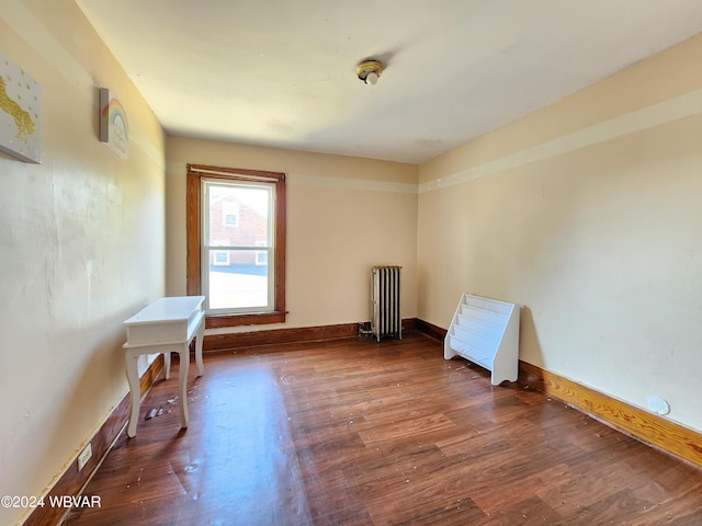 unfurnished room featuring dark hardwood / wood-style flooring and radiator