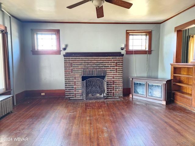 unfurnished living room with a wealth of natural light, dark hardwood / wood-style flooring, and a brick fireplace