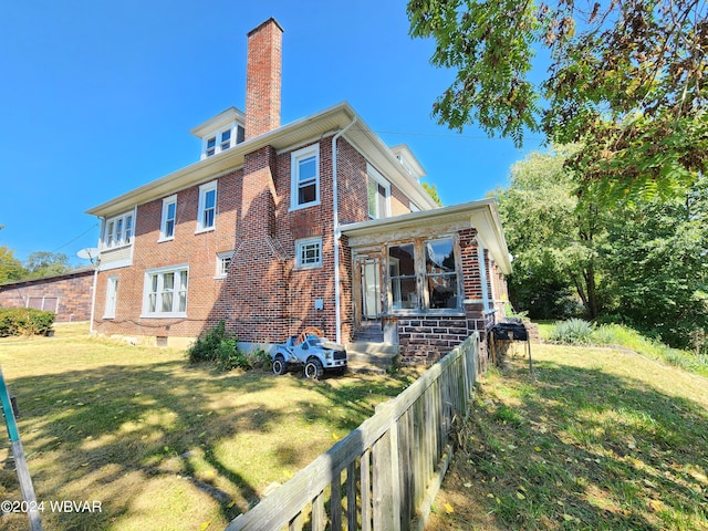 rear view of property with a lawn