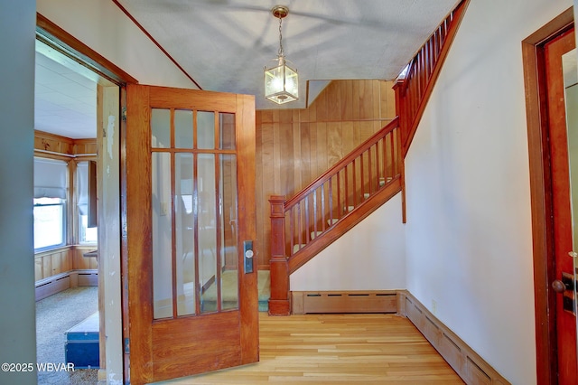104 Pearl St, Lock Haven, PA 17745 - foyer entrance featuring stairs, baseboard heating, a baseboard heating unit, wood finished floors, and wooden walls