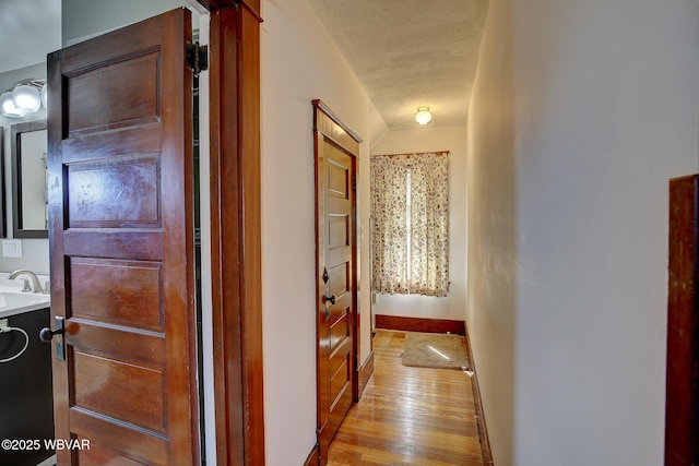 104 Pearl St, Lock Haven, PA 17745 - corridor featuring light wood finished floors, a textured ceiling, baseboards, and a sink
