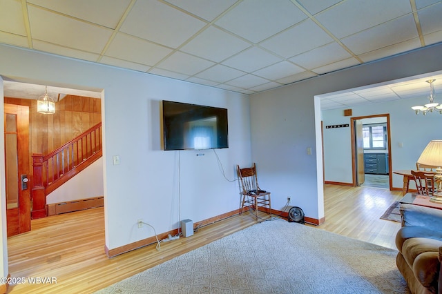 104 Pearl St, Lock Haven, PA 17745 - living area with a chandelier, baseboard heating, wood finished floors, stairway, and baseboards