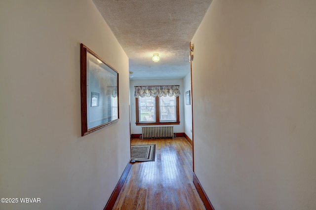 104 Pearl St, Lock Haven, PA 17745 - corridor with radiator heating unit, wood-type flooring, a textured ceiling, and baseboards