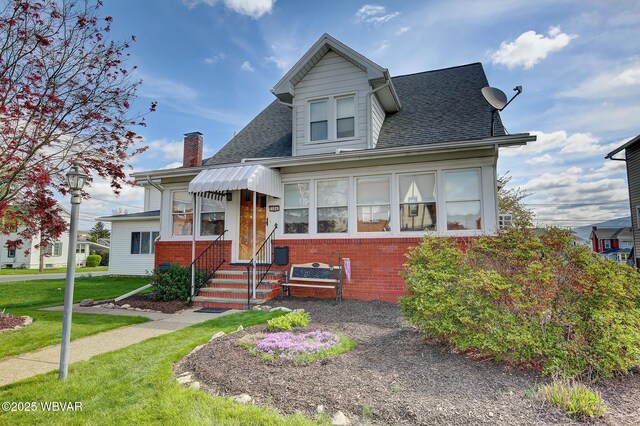 104 Pearl St, Lock Haven, PA 17745 - view of front of home with entry steps, brick siding, roof with shingles, and a front yard