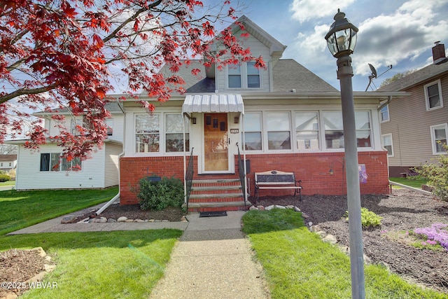 104 Pearl St, Lock Haven, PA 17745 - view of front facade featuring brick siding, entry steps, a front yard, and roof with shingles
