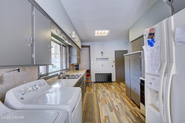 104 Pearl St, Lock Haven, PA 17745 - washroom featuring radiator, light wood-style flooring, and washer and clothes dryer