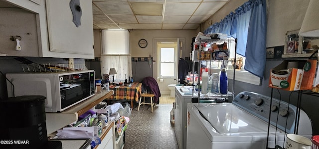kitchen featuring white microwave, a drop ceiling, washer / dryer, and tile patterned floors