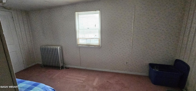 carpeted bedroom with radiator and baseboards