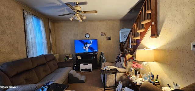 carpeted living room featuring stairs and a ceiling fan