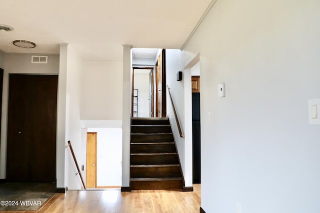 staircase with hardwood / wood-style flooring and crown molding