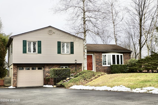 split level home with a front yard and a garage