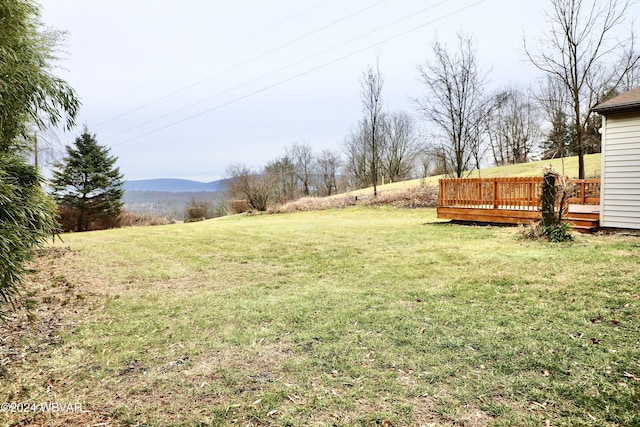 view of yard featuring a deck with mountain view