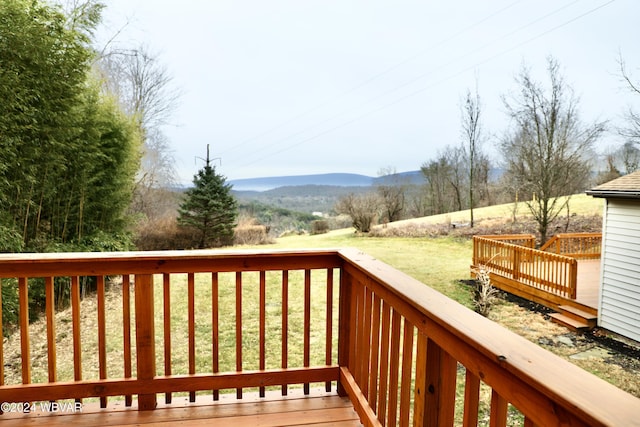 deck featuring a mountain view and a yard