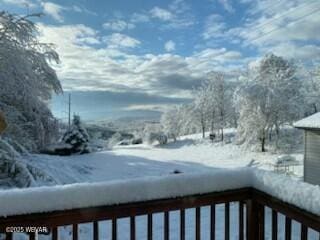 view of snow covered back of property