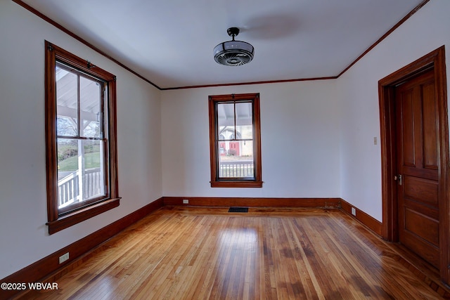 unfurnished room featuring light wood-style flooring, a healthy amount of sunlight, and baseboards