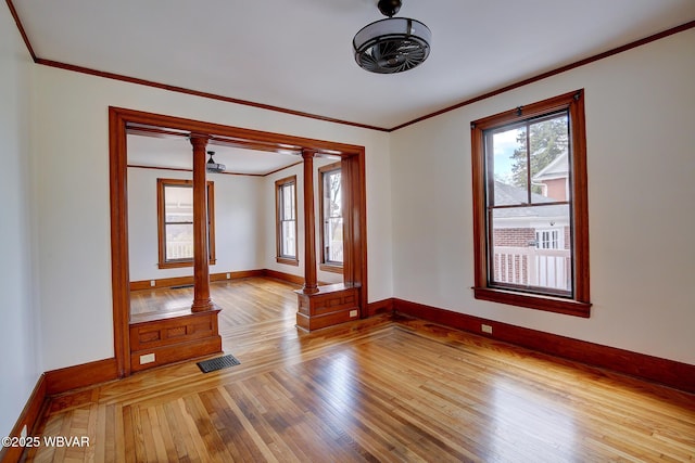 spare room with visible vents, baseboards, ornate columns, and light wood-style floors