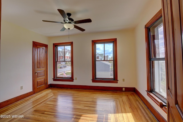 empty room with light wood-type flooring, baseboards, and a ceiling fan