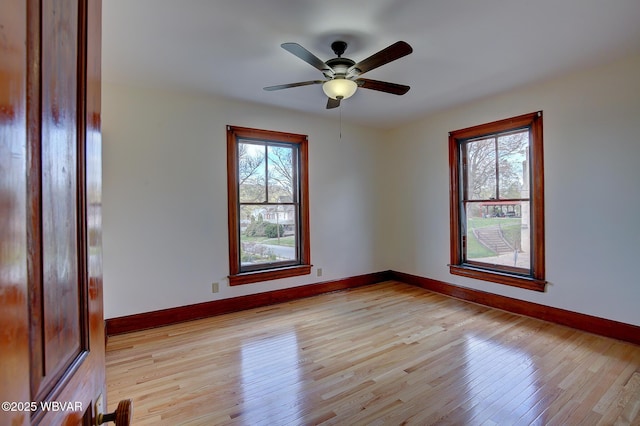 unfurnished room featuring light wood-style flooring, baseboards, and a ceiling fan