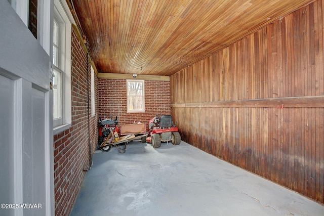sitting room featuring wood ceiling, brick wall, wooden walls, and concrete floors