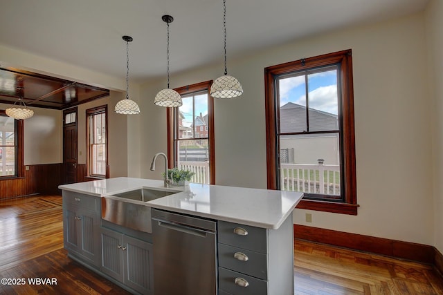 kitchen with gray cabinets, stainless steel dishwasher, a sink, and light countertops