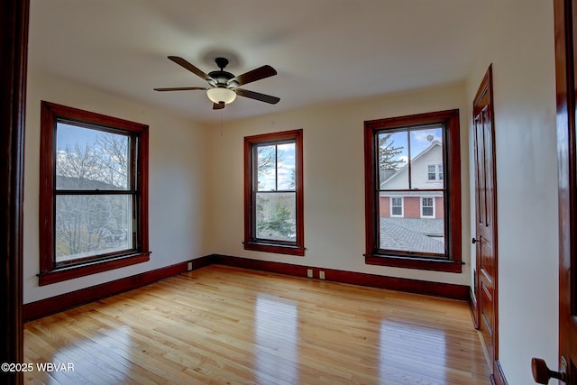unfurnished room with light wood-style flooring, baseboards, and a healthy amount of sunlight